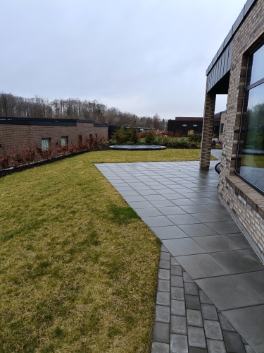 haveanlæg med græsplæne og terrasse